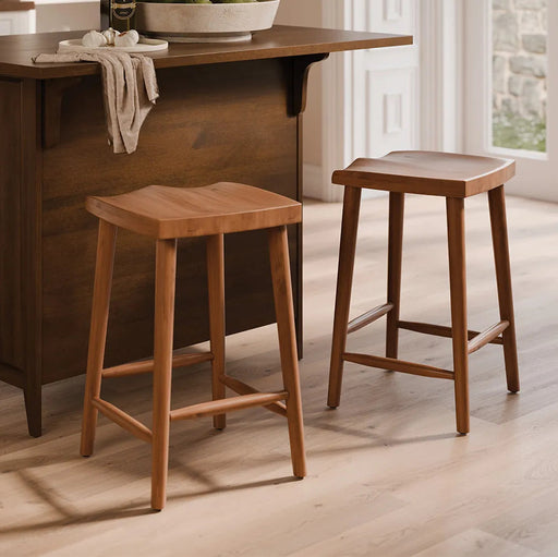Two wooden bar stools with a warm medium-brown finish, shown in a bright kitchen setting next to a matching wooden island.