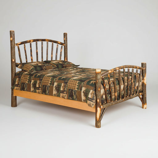 A rustic log cabin bed frame made from natural tree branches with curved headboard and footboard, shown with camouflage bedding on a plain white background.