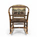 A rustic log-style rocking chair with a brown leather seat and a backrest featuring a green and beige bear and tree pattern, shown in a furniture store.