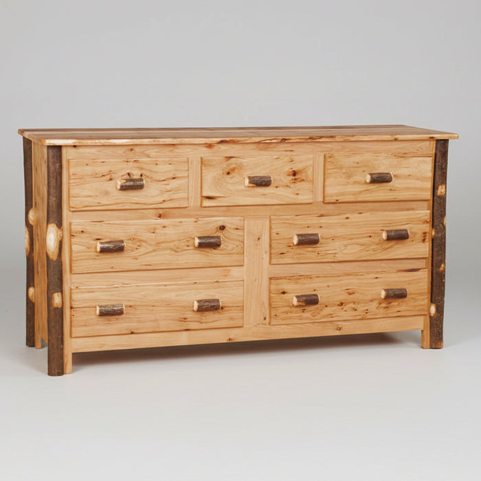 A rustic wooden dresser with seven drawers, featuring natural wood grain, dark brown end-grain accents on the legs, and small log-shaped metal handles.
