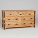 A rustic wooden dresser with seven drawers, featuring natural wood grain, dark brown end-grain accents on the legs, and small log-shaped metal handles.