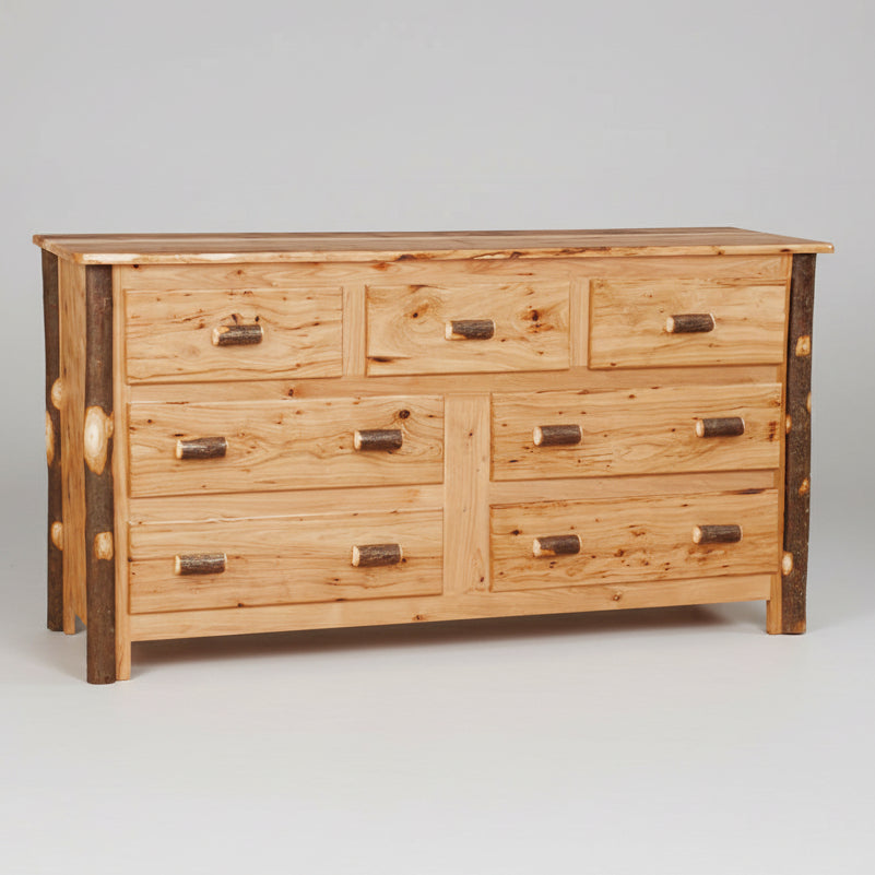 A rustic wooden dresser with seven drawers, featuring natural wood grain, dark brown end-grain accents on the legs, and small log-shaped metal handles.