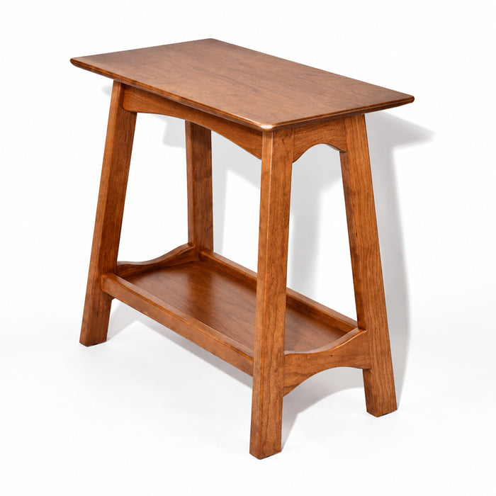 A wooden side table with a warm medium-brown finish, featuring a rectangular top, four legs, and an open lower shelf, shown on a plain white background.