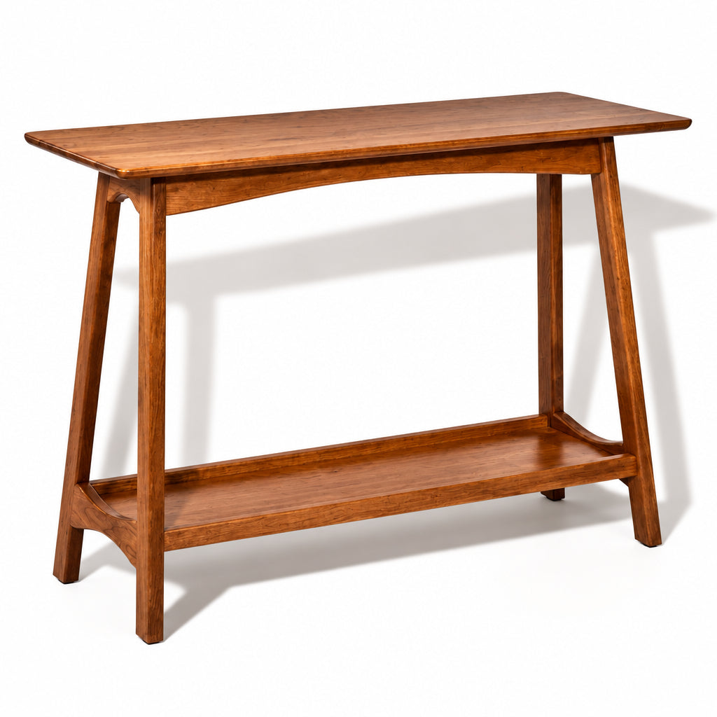 A mid-century modern wooden console table with a warm medium-brown finish, featuring a slanted top, angled legs, and a lower shelf, shown on a plain white background.