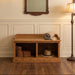 A wooden bench with two open storage compartments, featuring a medium brown oak wood grain finish and a decorative backrest, shown on a solid white background.