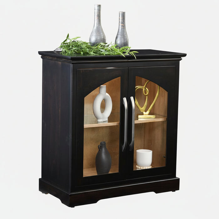 A black wooden side cabinet with two glass-front doors, styled with decorative vases and greenery on top, shown against a plain white background.