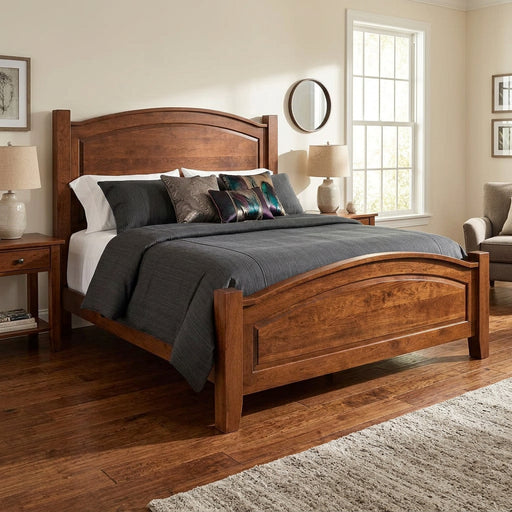 A wooden bed frame with a curved headboard and footboard, styled with dark gray bedding, striped pillows, and beige accent pillows on a white background.
