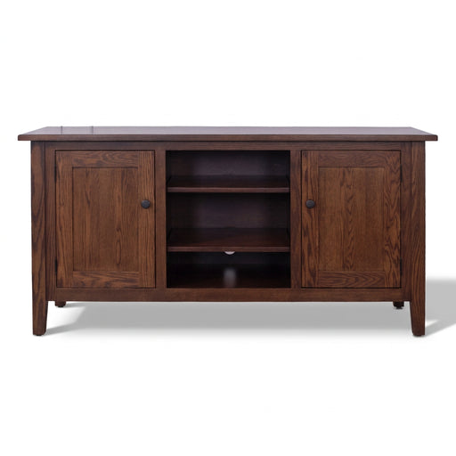 A dark brown wooden media console with two paneled cabinet doors, two open shelves in the center, and small round dark knobs, shown against a plain white background.