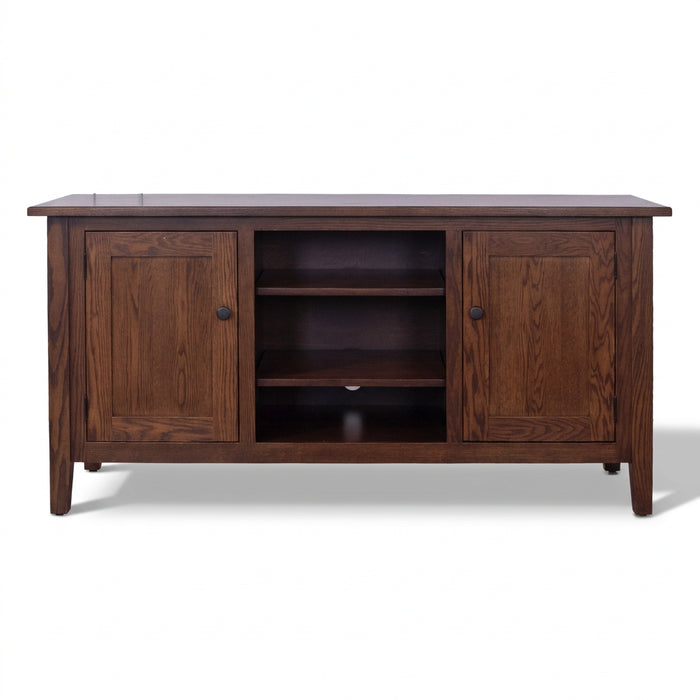 A dark brown wooden media console with two paneled cabinet doors, two open shelves in the center, and small round dark knobs, shown against a plain white background.