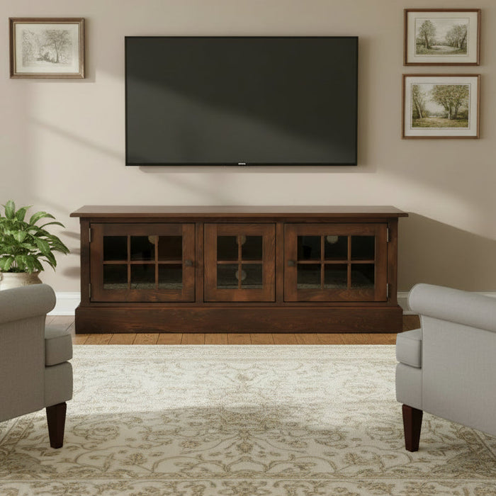 A dark brown wooden media console with three glass-paneled doors, shown on a light gray gradient background.