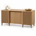 A mid-century modern sideboard cabinet in a light oak wood finish, styled with two white ceramic vases and a woven basket bowl on top, set against a solid white background.