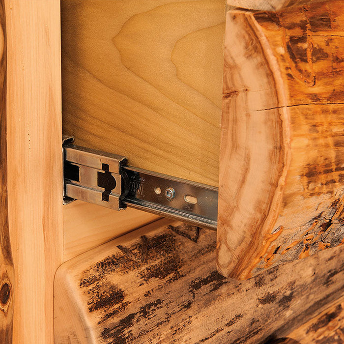 Close-up of a rustic log furniture piece with a metal drawer slide mechanism, showing natural wood grain and bark details against a white background.