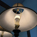 Close-up of a lamp with a visible light bulb against a dark background