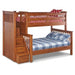 A wooden bunk bed with an attached staircase and under-bed storage drawers, shown on a plain white background. The lower bed is dressed in a blue and white plaid sheet and pillowcase, and the upper bed has a red and white floral patterned sheet and a red polka-dot pillow.