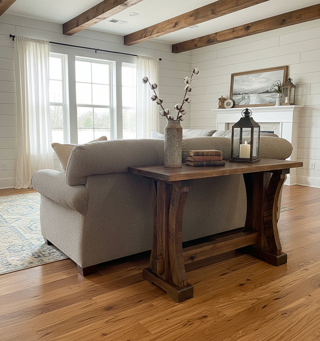 Wooden console table in a furniture store setting with sofas and decor items.